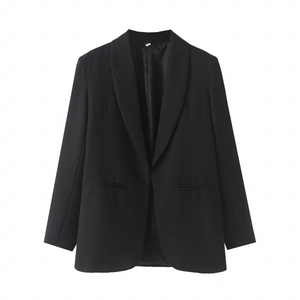 Gros plan du col du blazer noir montrant la texture lisse du tissu et l'étiquette S