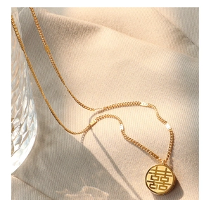Détail du collier en acier titane plaqué or 18k avec pendentif ajouré Double Bonheur