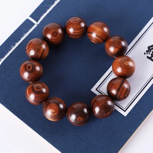 Macro shot of natural green sandalwood beads with distinct grain on antique book background