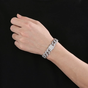 Nahaufnahme von silbernem Iced-Out Cuban-Kettenarmband mit Strass auf dem Handgelenk