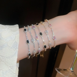 Elegant adjustable crystal bracelets with colorful gemstones on a wrist in soft lighting