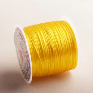 Macro shot of yellow elastic crystal string on white spool with laser anti-counterfeit label
