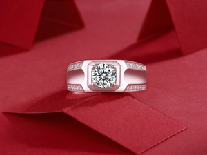 Macro shot of men's silver ring with round moissanite on a vibrant red background