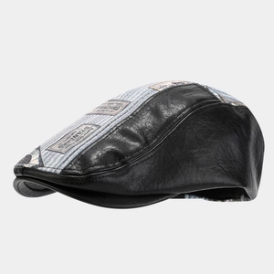 Detail of vintage patchwork newsboy cap featuring black leather and blue striped canvas