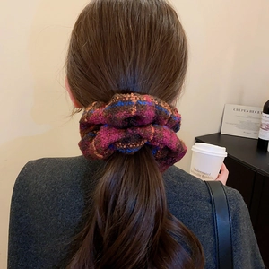 Gros plan du chouchou tricoté à carreaux violet et bleu, porté dans les cheveux