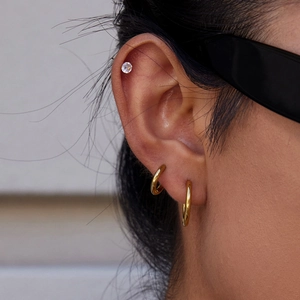 Détail de créoles en acier inoxydable plaqué or 18K et d'une puce en zircone