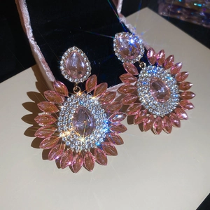 Macro shot of luxury oversized floral drop earrings with pink teardrop stones and crystals
