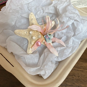 Close-up of starfish hair clip with pink silk petals and sparkling rhinestone decoration