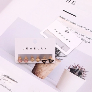 Three pairs of elegant stud earrings including pink round and black triangle styles on a card