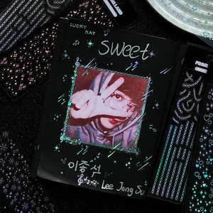 Holographic laser star stickers decorating a black photo card holder for DIY journals
