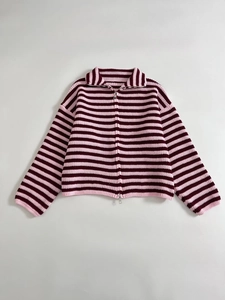 Dettaglio del tessuto a maglia a righe rosa e bordeaux con cerniera in metallo argento