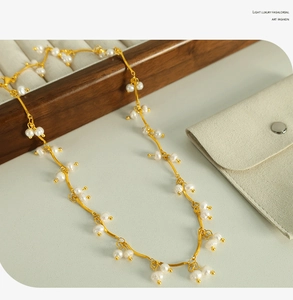 Detail of freshwater pearl tassel necklace on jewelry box with vintage golden chain