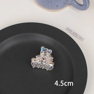 Detail of 4.5cm iridescent laser bear hair claw clip on a sleek minimalist black tray