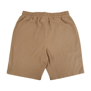 Detail view of khaki linen beach shorts showing elastic waist and breathable fabric texture