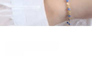 Detail view of a gold-plated titanium bracelet with elegant blue beaded enamel design