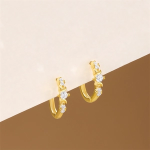 Detailed view of gold hoop earrings featuring micro-pave white zircons and crescent moon motif