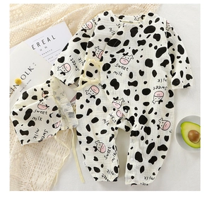 Close-up detail of breathable cotton gauze baby romper featuring a cute cow print pattern