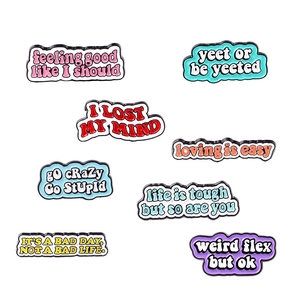 Set of 8 colorful enamel metal pins with inspirational and slang typography on white background