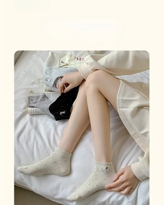 Detail of breathable low-cut cotton socks with cute dog embroidery and polka dots