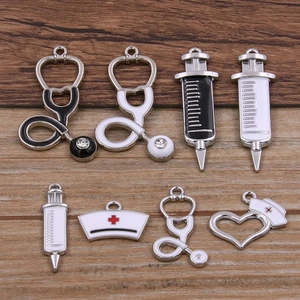 8-piece medical charm set with stethoscope and syringe pendants on wood background
