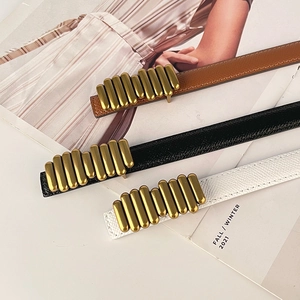 Three leather belts in black white and brown with vintage cylindrical gold buckles