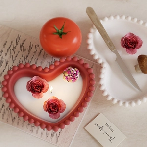 Detailed close-up of heart-shaped candle mold with beaded edges and floral resin inserts