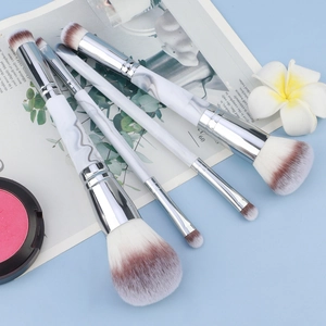 Four-piece marble pattern makeup brush set with powder and eyeshadow brushes on blue background