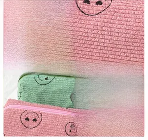 Detailed close-up of corduroy makeup bag fabric showing fine stitching and smiley pattern