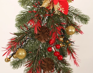 Detailed close-up of a Christmas teardrop swag with red berries and golden baubles