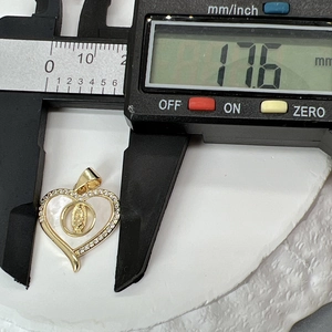 Macro shot of 17.6 mm wide gold heart pendant with white mother of pearl and tiny diamonds
