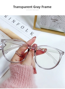 Detailed view of oversized transparent grey eyewear frame held in hand for fashion styling