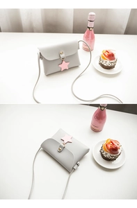 Mini flap crossbody bag in light grey with gold buckle and pink star charm detail