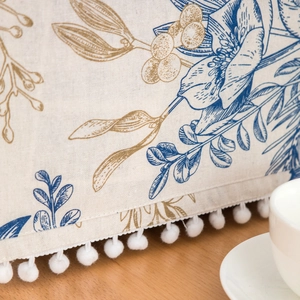 Cotton linen microwave cover with blue and gold floral patterns and white pompom fringe