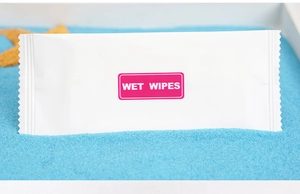Macro shot of single-wrapped wet wipes on blue sand with a starfish decoration