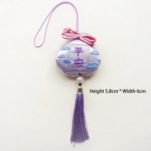 Detalle de la bolsa de la suerte de seda morada con bordado chino y borla de seda