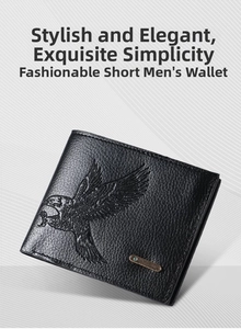 Detail of black leather wallet with embossed eagle pattern and textured litchi grain finish