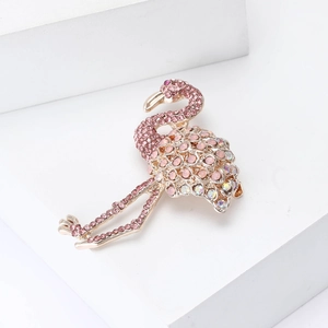 Close-up of elegant pink rhinestone flamingo brooch on a minimalist white display