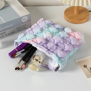 Detail of gradient bubble quilted cosmetic bag showing large capacity for beauty tools