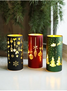 Detailed close-up of three Christmas LED candle lights with gold festive cutout patterns