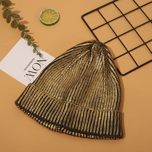 Detail shot of the golden metallic knit texture on a black Harajuku style beanie hat