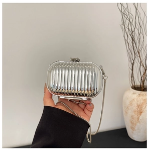 Detail of silver acrylic clutch bag with vertical striped texture and metal chain strap