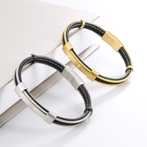Detail of woven leather bracelets with gold and silver steel plates on a book corner