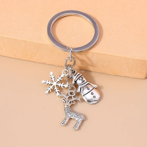 Detailed close-up of silver Christmas keychain featuring snowman, reindeer and snowflake charms