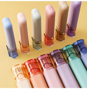 Macro view of assorted pastel portable plastic spray bottles arranged on yellow background