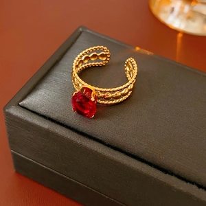Macro view of vintage style gold ring with red oval gemstone on black velvet box