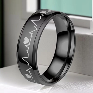 Close-up of black stainless steel ring featuring silver heartbeat and heart engravings