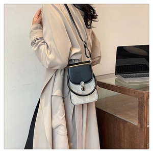 Detail of color-block PU crossbody bag with metal ring handle and silver shimmer texture