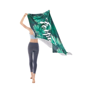 Microfiber beach towel featuring green tropical palm leaves and decorative script art