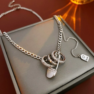 Detail of silver paperclip chain necklace with interlocking rings and love tag