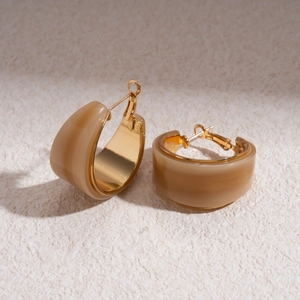 Detail view of retro C-shaped resin hoop earrings with golden metallic borders